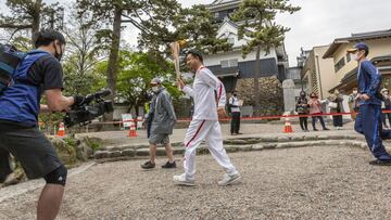 Un relevista porta la antorcha ol&iacute;mpica a su paso por el castillo de Okazaki.
