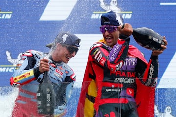 Marc Márquez y Jorge Martín celebran con champán en el podio. 