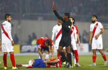 El árbitro venezolano José Argote (c) muestra la tarjeta roja al defensa peruano Carlos Augusto Zambrano (i) por una falta sobre el centrocampista chileno Charles Aranguiz , durante el partido Chile-Perú, de semifinales de la Copa América de Chile 2015