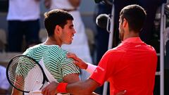 Serbia's Novak Djokovic (R) comforts Spain's Carlos Alcaraz Garfia after his victory during their men's singles semi-final match on day thirteen of the Roland-Garros Open tennis tournament at the Court Philippe-Chatrier in Paris on June 9, 2023. (Photo by Emmanuel DUNAND / AFP)