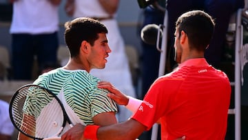 Serbia's Novak Djokovic (R) comforts Spain's Carlos Alcaraz Garfia after his victory during their men's singles semi-final match on day thirteen of the Roland-Garros Open tennis tournament at the Court Philippe-Chatrier in Paris on June 9, 2023. (Photo by Emmanuel DUNAND / AFP)