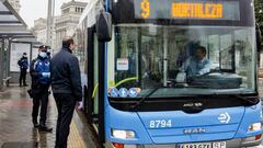 Un agente de la Polic&iacute;a Municipal de Madrid reparte mascarillas a los pasajeros de un autob&uacute;s de la l&iacute;nea 9 de la EMT