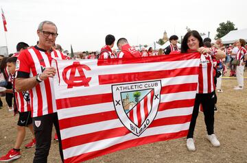 Aficionados del Athletic posan con una bandera de su equipo en la fan zone.
