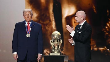 (L-R) US President Donald Trump looks on as he receives the FIFA Peace Prize from FIFA President Gianni Infantino during the draw for the 2026 FIFA Football World Cup taking place in the US, Canada and Mexico, at the Kennedy Center, in Washington, DC, on December 5, 2025. (Photo by Brendan SMIALOWSKI / AFP)