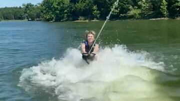 Miley Cyrus cayendo de cara al agua mientras practica wakesurf.