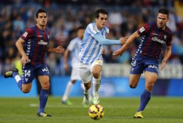 El delantero del Málaga Juan Miguel "Juanmi" (c) trata de escapar entre Dani García (i) y Jon Errasti, del Eibar, durante el partido de Liga en Primera División que disputan esta noche en el estadio de La Rosaleda, en Málaga. 