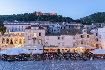 Comida: desde las 12:00 hasta las 14:00 horas | Cena: desde las 19:30 hasta las 20:30 horas. En la foto, la Plaza del Pueblo y la Fortaleza Española, en Hvar. 
 