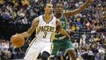 George Hill (3) intenta acercarse a la canasta ante Jordan Crawford (27).