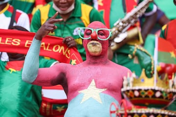 A football fan painted with the colours of the Burkina Faso national flag gestures 