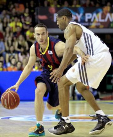 El base brasileño del FC Barcelona Marcelinho Huertas intenta avanzar ante la oposición del alero estadounidense del Real Madrid Tremmell Darden.