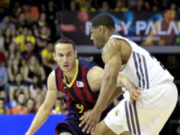 El base brasileño del FC Barcelona Marcelinho Huertas intenta avanzar ante la oposición del alero estadounidense del Real Madrid Tremmell Darden.