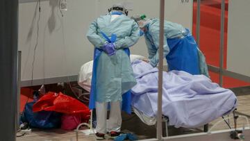 Dos sanitarios protegidos con mascarilla y gorro atienden a un paciente con coronavirus en el Hospital temporal de la Comunidad de Madrid habilitado en IFEMA, en Madrid (España) a 31 de marzo de 2020.
31 MARZO 2020 CORONAVIRUS;CAM;ENFERMEDAD;PROTECCIÓN;MASCARILLAS;OMS;SANIDAD;SISTEMA SANITARIO;HOSPITAL DE CAMPAÑA;COVID-19
Ricardo Rubio / Europa Press
31/03/2020