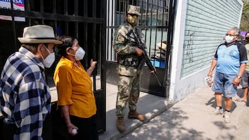 An Army soldier stands guard as senior citizens arrive to receive a dose of the Pfizer-BioNTech coronavirus disease (COVID-19) vaccine in Lima, Peru March 23, 2021. REUTERS/Sebastian Castaneda