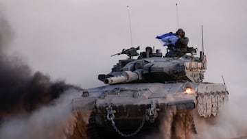 A soldier holds an Israeli flag, while riding on a tank, amid the ongoing conflict between Israel and Hamas, near the Israel-Gaza border, in Israel, June 13, 2024. REUTERS/Amir Cohen