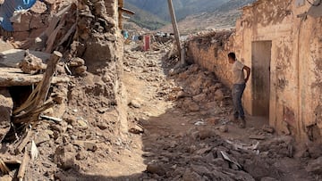 A person stands near damaged houses in Tafeghaghte, a remote village of the High Atlas mountains, following a powerful earthquake in Morocco, September 10, 2023.  REUTERS/Ahmed El Jechtimi