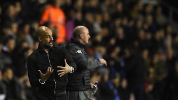 Manchester City&#039;s Spanish manager Pep Guardiola (L) and Wigan Athletic&#039;s English Manager Paul Cook gesture during the English FA Cup fifth round football match between Wigan Athletic and Manchester City at the DW Stadium in Wigan, northwest Engl