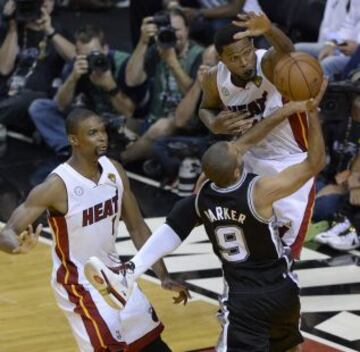 El alero Udonis Haslem de Miami para un disparode Tony Parker de San Antonio Spurs, en el centro Chris Bosh