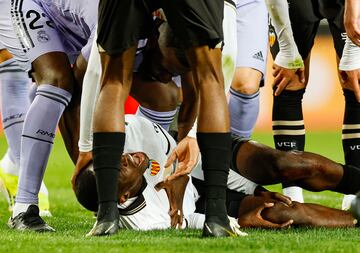 El defensa del Valencia se lleva las manos a la rodilla tras la acción accidental con Aurelien Tchouameni.