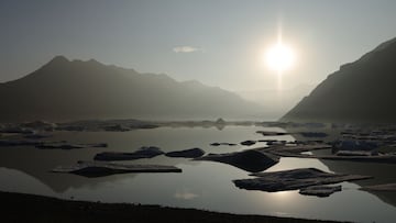 HOFN, HORNAFJORDUR, ICELAND - AUGUST 16: The sun sets over chunks of ice broken off from receding Heinabergsjokull glacier in a lake of the glacier&#039;s meltwater on August 16, 2021 near Hofn, Iceland. Iceland is feeling a strong impact from global warm