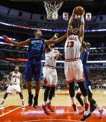 Joakim Noah coge un rebote en Roberts y Biyombo.