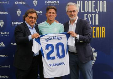 Giuliano Simeone posa con la camiseta del Real Zaragoza junto al director general Raúl Sanllehí y el director deportivo Miguel Torrecilla.