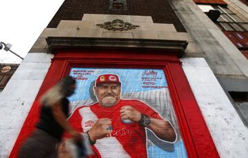 BUENOS AIRES, ARGENTINA - NOVEMBER 27: A woman walks past a mural of Diego Maradona on November 27, 2020 in Buenos Aires, Argentina. He is considered among the best footballers in history and lead his national team to the World Cup in 1986. P