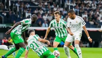 MADRID, 01/09/2024.- El delantero francés del Real Madrid Kylian Mbappé (d) lucha con Marc Roca, del Betis, durante el partido de la cuarta jornada de LaLiga entre el Real Madrid y el Real Betis, este domingo en el estadio Santiago Bernabéu. EFE/Borja Sánchez-Trillo