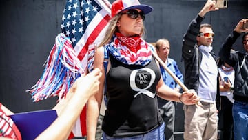 (FILES) In this file photo taken on May 1, 2020 Conspiracy theorist QAnon demonstrators protest during a rally to re-open California and against Stay-At-Home directives in San Diego, California. - Twitter has removed more than 7,000 accounts linked to the