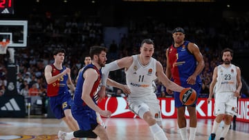 El alero croata del Real Madrid Mario Hezonja (d) se escapa de Darío Brizuela, del Barça, durante el partido de la jornada 27 de la EuroLiga que Real Madrid y Barça disputan este jueves en el Movistar Arena, en Madrid.