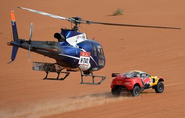 El piloto francés Sebastien Loeb y el copiloto belga Fabian Lurquin conducen su Brx seguido por el helicóptero del Dakar.