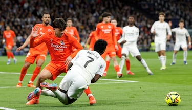 El defensa de la Real Sociedad derriba a Vinicius con su pierna izquierda.