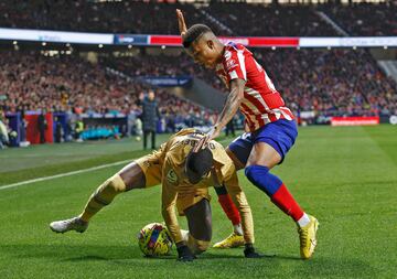 Ousmane Dembélé protege la pelota ante la presión de Reinildo Mandaba.