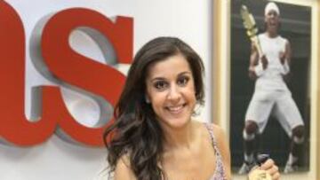 Carolina Marín sonríe en la redacción de AS con su medalla de oro de campeona del mundo y con la foto de su ídolo, Rafa Nadal, al fondo.