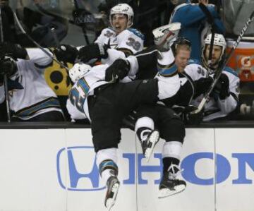 T.J. Galiardi (21) de los San Jose Sharks golpea al defensa de Los Angeles Kings Matt Greene (2) en el banquillo de los Sharks.