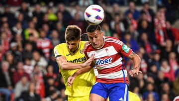 GRANADA, 30/10/2023.- El delantero albanés del Granada, Myrto Uzuni (d), remata ante el defensa italiano del Villarreal, Matteo Gabbia, durante el encuentro correspondiente a la jornada 11 de primera división disputado hoy lunes en el estadio Nuevo Los Carmenes de Granada. EFE / Miguel Ángel Molina.