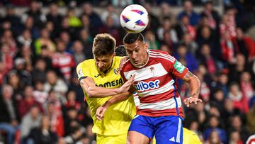 GRANADA, 30/10/2023.- El delantero albanés del Granada, Myrto Uzuni (d), remata ante el defensa italiano del Villarreal, Matteo Gabbia, durante el encuentro correspondiente a la jornada 11 de primera división disputado hoy lunes en el estadio Nuevo Los Carmenes de Granada. EFE / Miguel Ángel Molina.