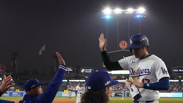 Los Angeles Dodgers Shohei Ohtani (R) high fives Manager Dave Roberts (L) after scoring during the Major League Baseball (MLB) National League Championship Series playoff game one between the New York Mets and the Los Angeles Dodgers in Los Angeles, California