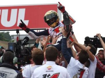 Repsol Honda Team rider Marc Marquez of Spain (C) celebrates with his team following his win of the 2014 MotoGP World Championship after finishing second place at the MotoGP Japanese Grand Prix in Motegi, Tochigi prefecture on October 12, 2014. AFP PHOTO / TOSHIFUMI KITAMURA