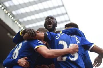 Everton's English defender Matthew Pennington (C) celebrates with Everton's Belgian striker Romelu Lukaku (C) and teammates after scoring their first goal during the English Premier League football match between Liverpool and Everton