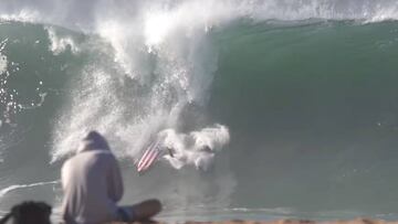 Un surfista con una tabla de surf con la bandera de los Estados Unidos sufre un wipeout en la ola gigante de The Wedge (Orange County, California) durante el 4 de julio, D&iacute;a de la Independencia de los EEUU. Un fot&oacute;grafo tira fotos desde la p