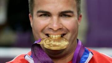 Cuba's Leuris Pupo bites his gold medal on the podium after winning the 25m rapid fire pistol men's final at the London 2012 Olympic Games at the Royal Artillery Barracks in London in August 3, 2012. AFP PHOTO/MARWAN NAAMANI
