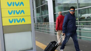 A man walks near a sign of the airline Viva Air, after the airline canceled all its flights due to the financial difficulties it is facing to operate at the El Dorado Airport, in Bogota, Colombia February 28, 2023. REUTERS/Luisa Gonzalez