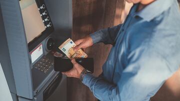 Close up of businessman withdrawing money and putting in the wallet