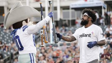 IMAGE DISTRIBUTED FOR RELIANT - Ezekiel Elliott of the Dallas Cowboys selects a bat from Dallas Cowboys mascot Rowdy during the Reliant Home Run Derby Wednesday, May 15, 2019 in Frisco, Texas. Elliott, nine other Cowboys teammates and head coach Jason Garrett participated in the event, which helped raise a total of $100,100 on behalf of Reliant for local charities.(Brandon Wade/AP Images for Reliant)