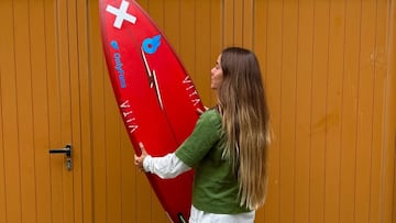 Alazne Aurrekoetxea con su tabla de surf y las pegatinas de sus sponsors: Blue Banana, Vita y OnlyFans