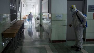 This photo taken on July 5, 2020 shows staff members wearing protective clothing spraying disinfectant in the compounds of a school ahead of the National College Entrance Examination (NCEE), known as Gaokao, in Wuhan in China&#039;s central Hubei province