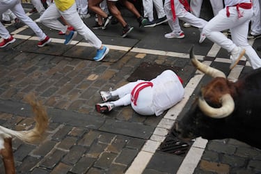 Participantes corren delante de los toros durante el primer encierro de los Sanfermines en Pamplona.