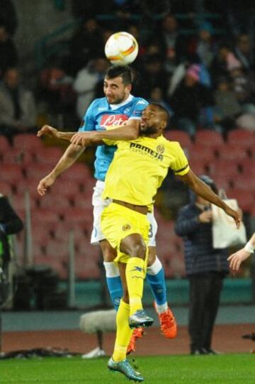 El jugador del Nápoles Raul Albiol cabecea el balón ante la marca de Cedric Bakambu, del Villarreal, durante un partido por la Liga Europa entre el Nápoles y el Villarreal.