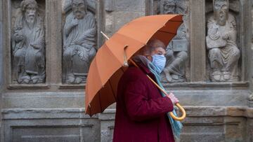 A woman walks along the empty Quintana Square next to the Cathedral of Santiago de Compostela in northwestern Spain on January 27, 2021 amid new coronavirus restrictions. - Spain has recorded more than 55,000 deaths from nearly 2.5 million cases of Covid-