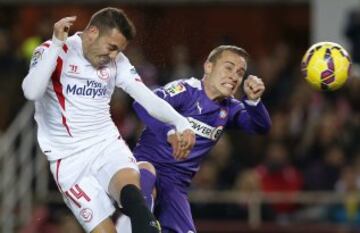El delantero del Sevilla Iago Aspas remata de cabeza ante el centrocampista del RCD Espanyol Abraham González, durante el partido de la vigésimo primera jornada de Liga de Primera División.